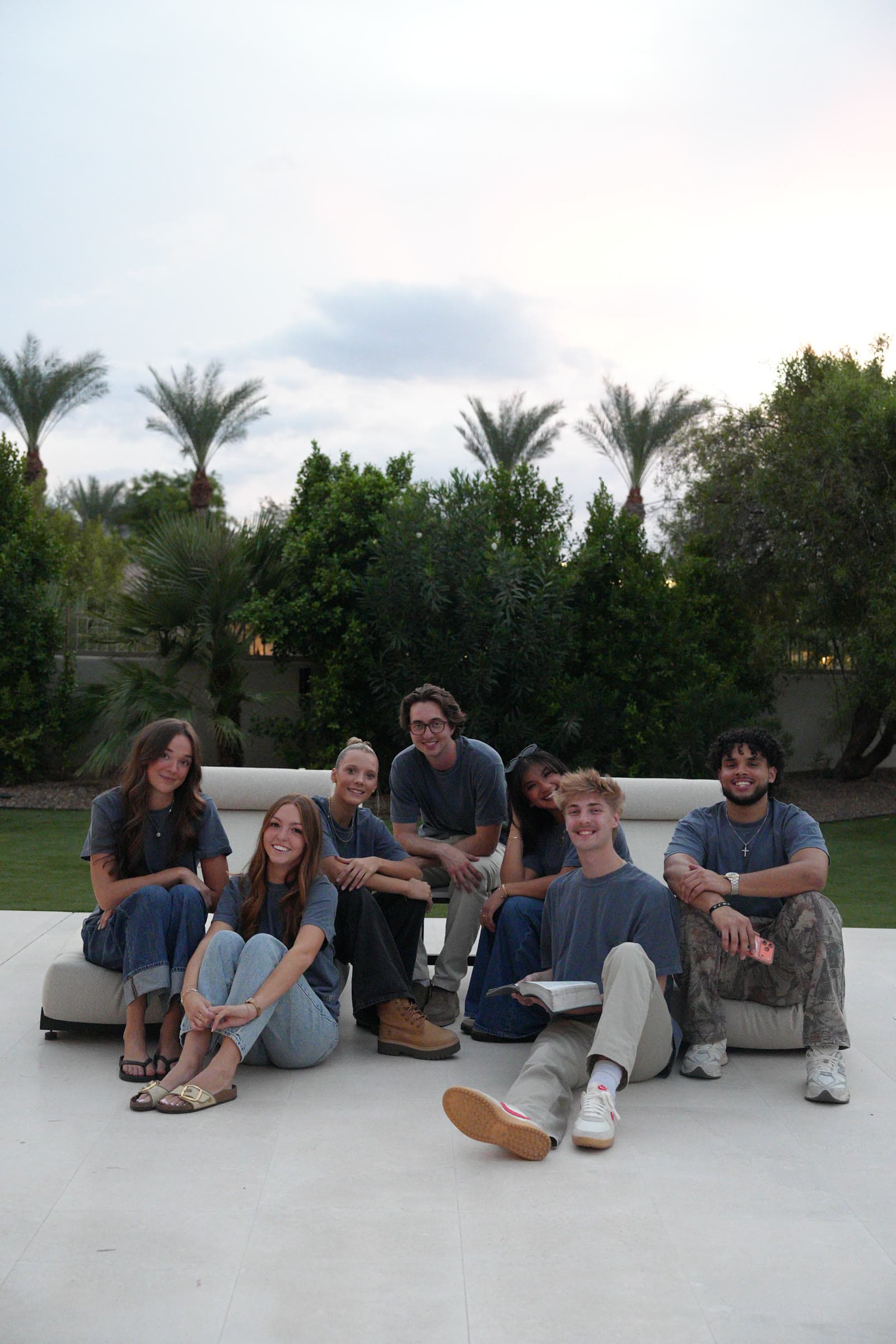 A group of friends sitting together in the tee at dusk